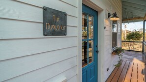 A house with a blue door and a sign that reads "The Nguenot."