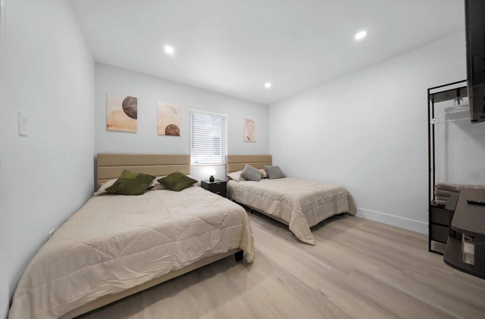 Una camera da letto con due letti, un comodino e una scrivania con una sedia.