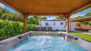 A hot tub under a wooden pergola with a view of a house and lush greenery. - New Design Dist Gem:Pool,HotTub,Minigolf,Nespresso (Miami)