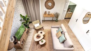 A modern living room with a sofa, coffee table, and a dining area with a wooden table and chairs. - Cozy duplex - patio - sleeps 6 - historic village (Saint-Paul-Trois-Châteaux)