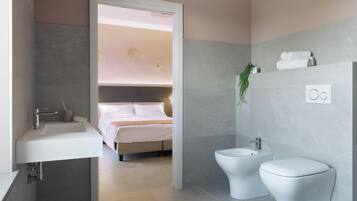 Un baño moderno con lavamanos, bidé e inodoro.