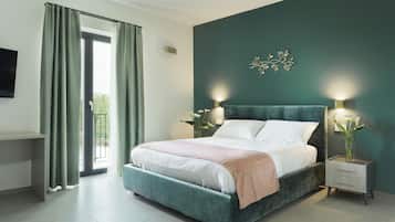 A bedroom with a bed, bedside tables, a TV, and a view of the outdoors.