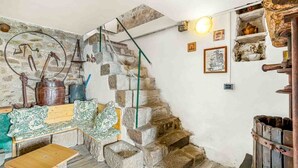 Une pièce rustique avec un escalier en pierre, un banc en bois et une petite table.