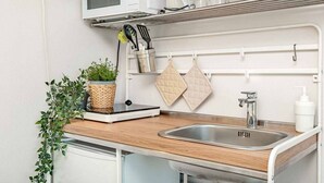 A compact kitchen with a microwave, a sink, and a small countertop. - Sea Forest - Ginko, Sea Lands (Bonassola)