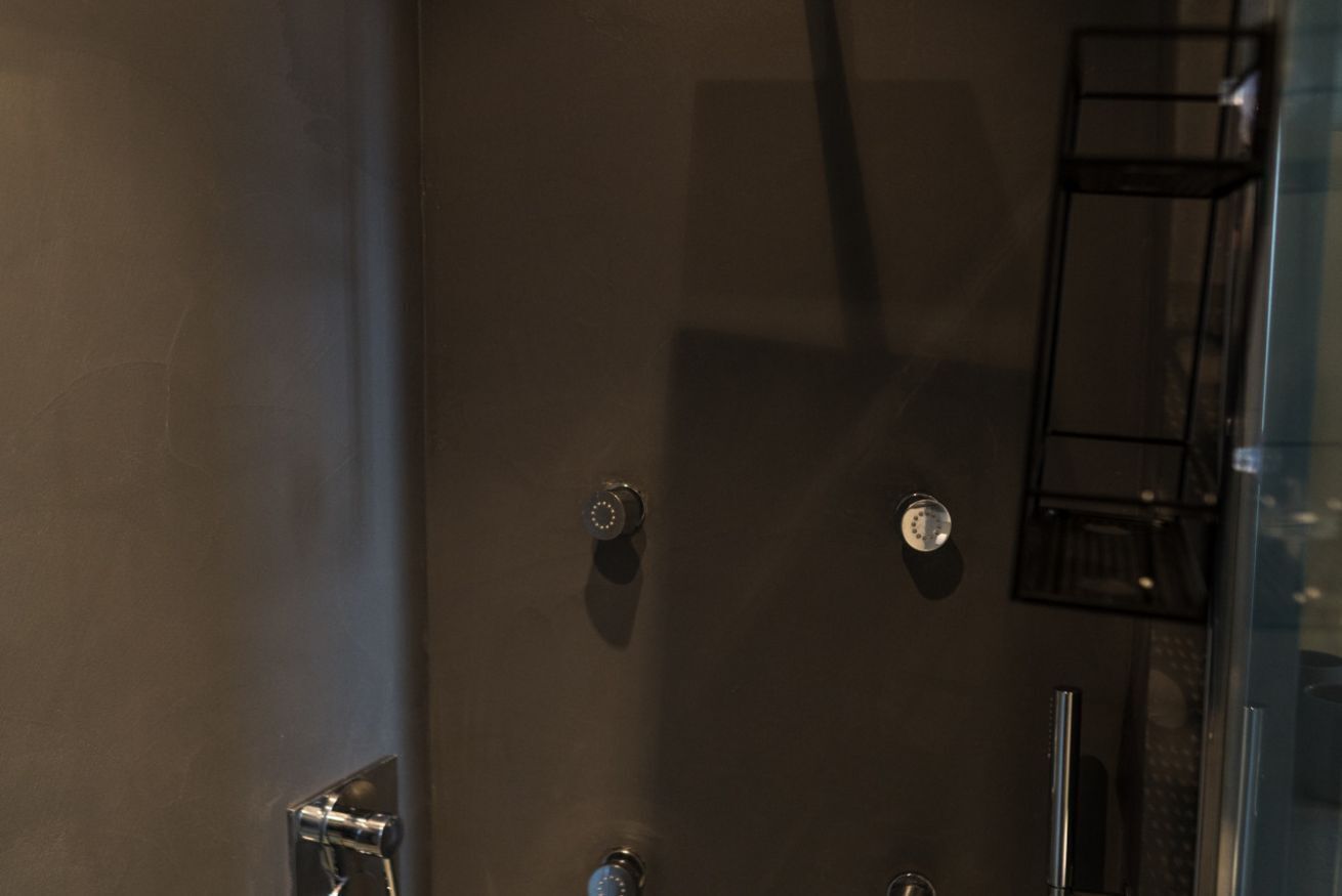 Une salle de bain moderne avec un grand miroir, une douche et une paroi de verre.