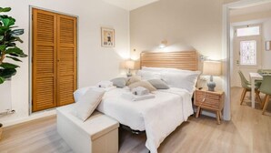Une chambre bien rangée, avec un lit, des tables de chevet, une chaise, un bureau et une armoire.