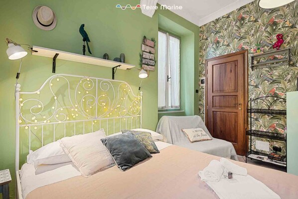 Un dormitorio con dos camas, un armario y una estantería con objetos decorativos.