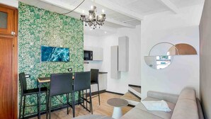 A modern living room with a dining area, a flat-screen TV, a chandelier, and a sofa. - Enchantment, TerreMarine (Riomaggiore)