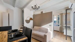 A modern dining area with a wooden table, black chairs, and a beige sofa. - Enchantment, TerreMarine (Riomaggiore)