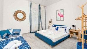 A bedroom with two beds, a ceiling fan, a wooden ladder, and a framed picture of a flamingo. - Corner 89, TerreMarine (Monterosso al Mare)