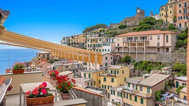 Une ville côtière aux bâtiments aux couleurs vives, dotée d’un imposant beffroi et offrant une vue sur la mer.