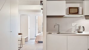 A modern kitchen with a built-in microwave, a stainless steel sink, and a kettle. - Via del Mare, Terre Marine (Riomaggiore)