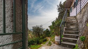 A stone staircase leading to a building with a garden path and greenery. - The Chalet by the Sea, Terre Marine (Vernazza)