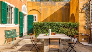 A courtyard with a stone table and chairs, a bench, and a hedge. - The Secret Garden, TerreMarine (Lerici)