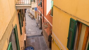 En smal gade med en café, der hedder 'CJF Café', og en bar, der hedder 'Bar Nungio'.