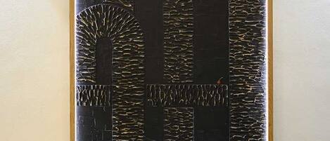 A framed abstract art piece with geometric shapes and patterns.