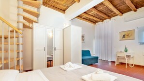 A bedroom with a bed, a wardrobe, a desk, and a chair.