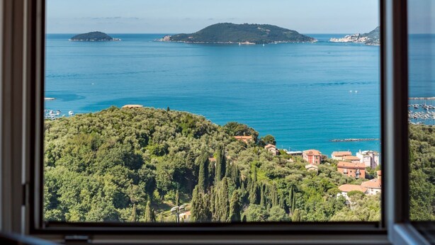 A coastal view from a window, including a hill with buildings, a small island, and the sea. - Viewpoints, nature, walks and sea (Lerici)