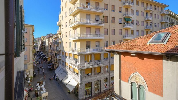 A multi-story hotel with balconies, a central courtyard, and a red-tiled roof.