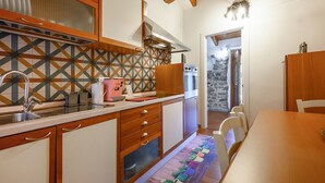 Una cocina compacta con armarios de madera, horno integrado y un salpicadero con diseño.