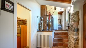 Una escalera de madera con peldaños que conducen a un rellano, un radiador y una puerta con un letrero.