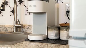 Moderni keittiö, jossa on Keurig-kahvinkeitin, pesuallas ja työtaso, jonka taustaseinässä on tähtikuvioita.