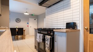 Una cocina moderna con estufa, horno y una pequeña radio negra en la encimera.