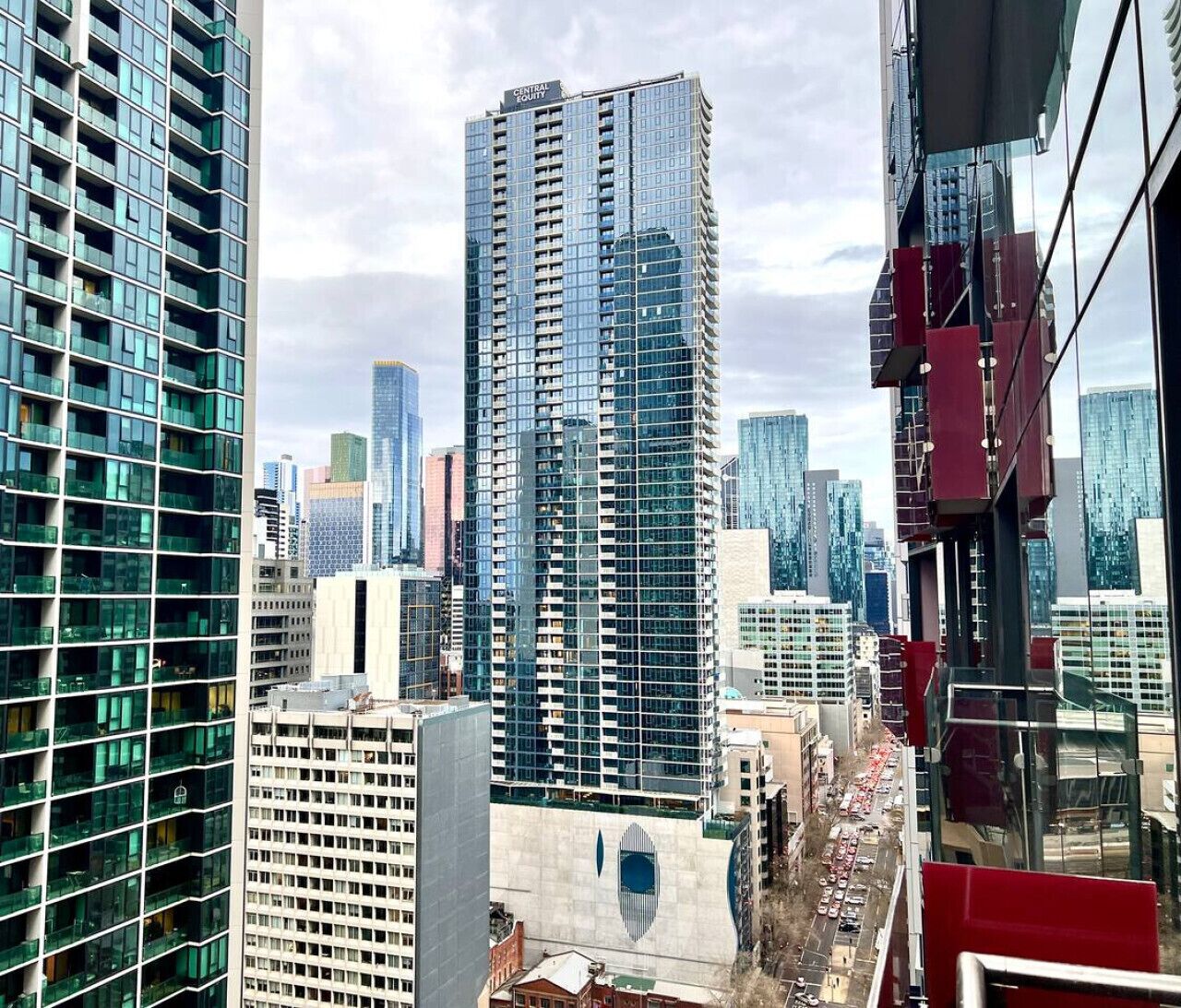 A high-rise building with a modern glass facade, surrounded by other tall buildings in an urban setting.