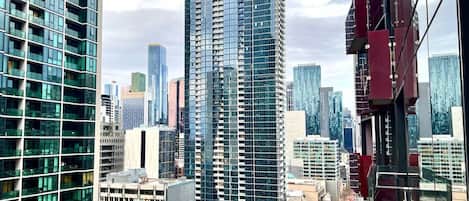 A high-rise building with a modern glass facade, surrounded by other tall buildings in an urban setting.