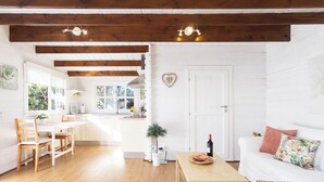 A bright, open-plan living and dining area with wooden beams, white walls, and a white door. - Home2Book Comfy Cottage Hibiscus, Peace Retreat (La Orotava)