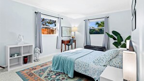 Une chambre à coucher avec un lit, un bureau, une chaise, une carte accrochée au mur et une fenêtre avec des rideaux.
