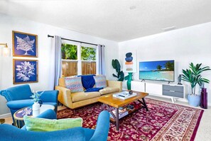Una sala de estar con sofá, mesa de centro y televisor.