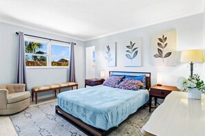 A bedroom with a bed, bedside tables, a chair, a window with curtains, and wall art. - Charming Villa 14 mins away from Siesta Key Beach (Sarasota)