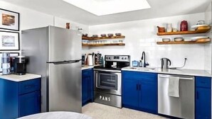 A modern kitchen with blue cabinets, stainless steel appliances, and a built-in oven. - Charming Villa 14 mins away from Siesta Key Beach (Sarasota)