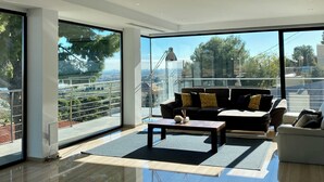 A modern living room with a large window, a sofa, a coffee table, and a rug.
