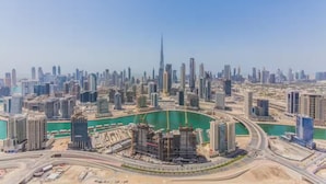 Une vue urbaine avec un gratte-ciel imposant, une marina et des immeubles de grande hauteur environnants.
