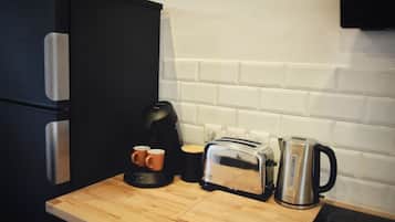 Un plan de travail de cuisine avec un grille-pain, une bouilloire et une machine à café.