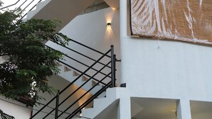 A multi-level building with a staircase, a covered outdoor area, and a large window with a curtain. - The Villa Sea Breeze (Thalpe)