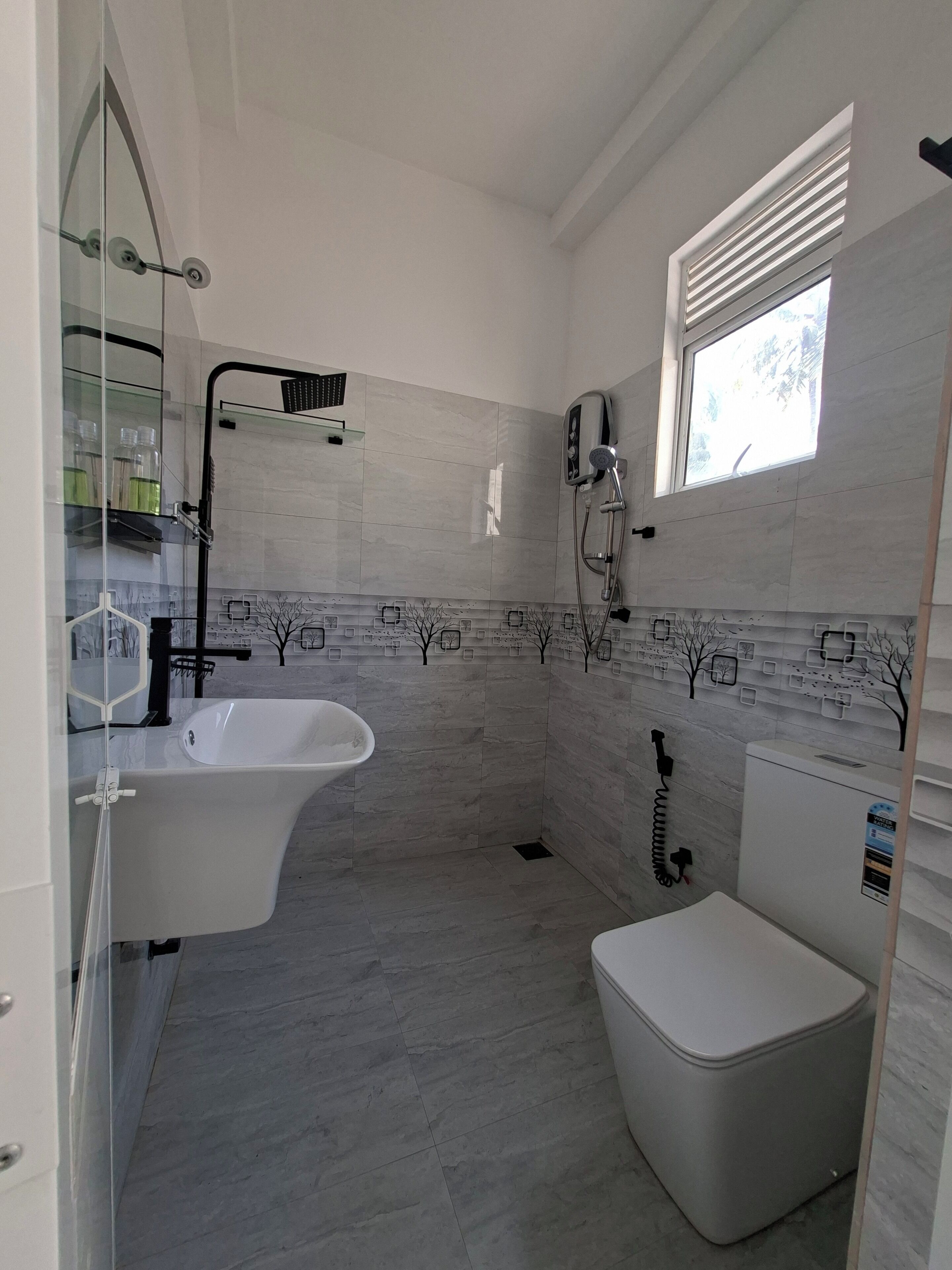 Et moderne badeværelse med et fristående badekar, en brusehoved og et toilet.