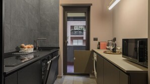 Cozinha moderna com máquina de lavar louça, micro-ondas e pia.