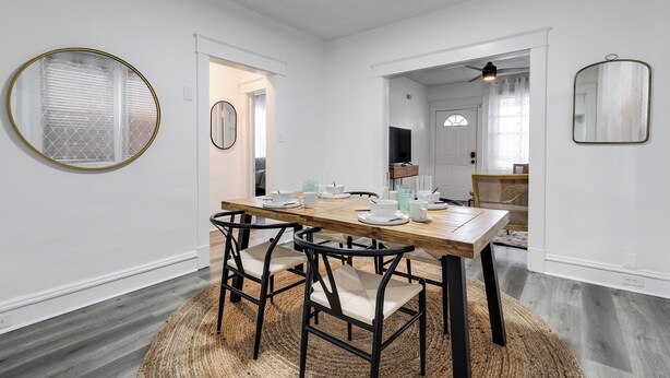 A dining area with a wooden table set for six, surrounded by black chairs with beige cushions. - Charming 2-bedroom house with AC, WiFi in wonderful Richmond (Richmond)