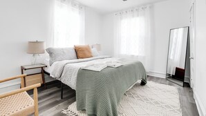 A bedroom with a bed, a nightstand, a lamp, a chair, and a ceiling fan. - Charming 2-bedroom house with AC, WiFi in wonderful Richmond (Richmond)
