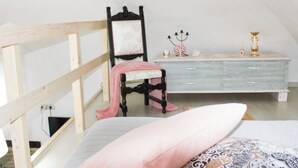 A bedroom with a wooden bunk bed, a small chair, a dresser, and a candelabra. - [Domus Helianthus]Cozy Loft, Wifi,Parking (Salandra)
