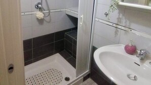A modern bathroom with a glass shower enclosure, a white sink, and a mirror. - [Domus Helianthus]Cozy Loft, Wifi,Parking (Salandra)