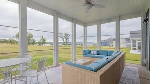 A covered patio with a wicker sofa, a dining table, and chairs. - 2728 Harbor Court (Delavan)