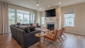 A spacious living room with a gray sectional sofa, a wooden coffee table, and a fireplace. - 2728 Harbor Court (Delavan)