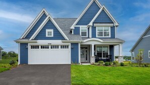 A two-story house with a garage, a covered front porch, and a well-maintained lawn. - 2728 Harbor Court (Delavan)
