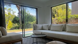 A modern living room with a white sofa, a patterned rug, and a coffee table. - Bryanston Luxurious 4-Bed Villa (Sandton)
