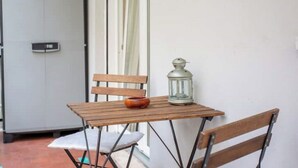 A small wooden table with a lantern and a bowl on it, a wooden chair, and a door with a handle.