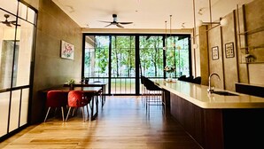 Una cocina moderna con una isla grande, un comedor con sillas y un ventilador de techo.